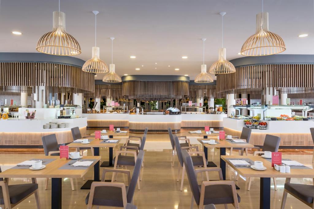 a rendering of a restaurant with tables and chairs at Barceló Corralejo Bay - Adults Only in Corralejo