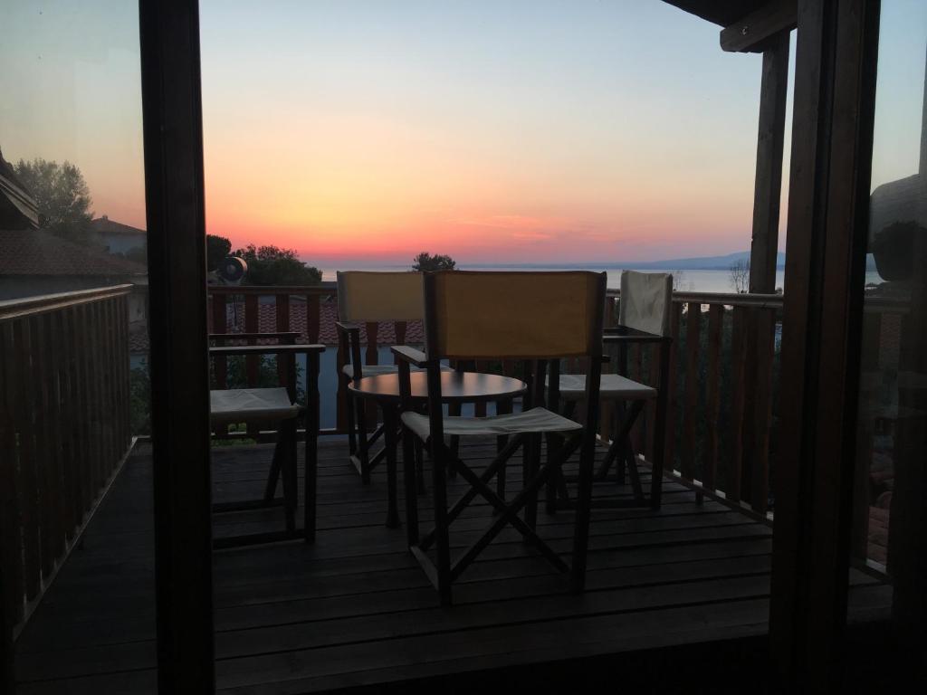 a balcony with chairs and a table and a sunset at Dimitra House in Metókhion Patriotikón