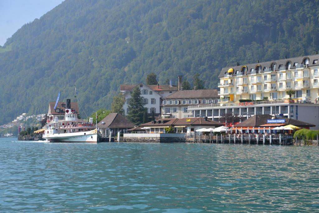 um barco está ancorado ao lado de uma cidade na água em Seehotel Riviera at Lake Lucerne em Gersau