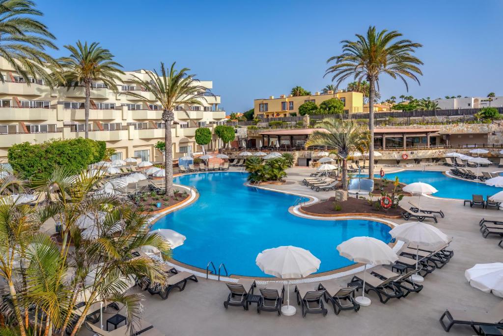 an overhead view of a resort pool with chairs and palm trees at Barceló Corralejo Bay - Adults Only in Corralejo