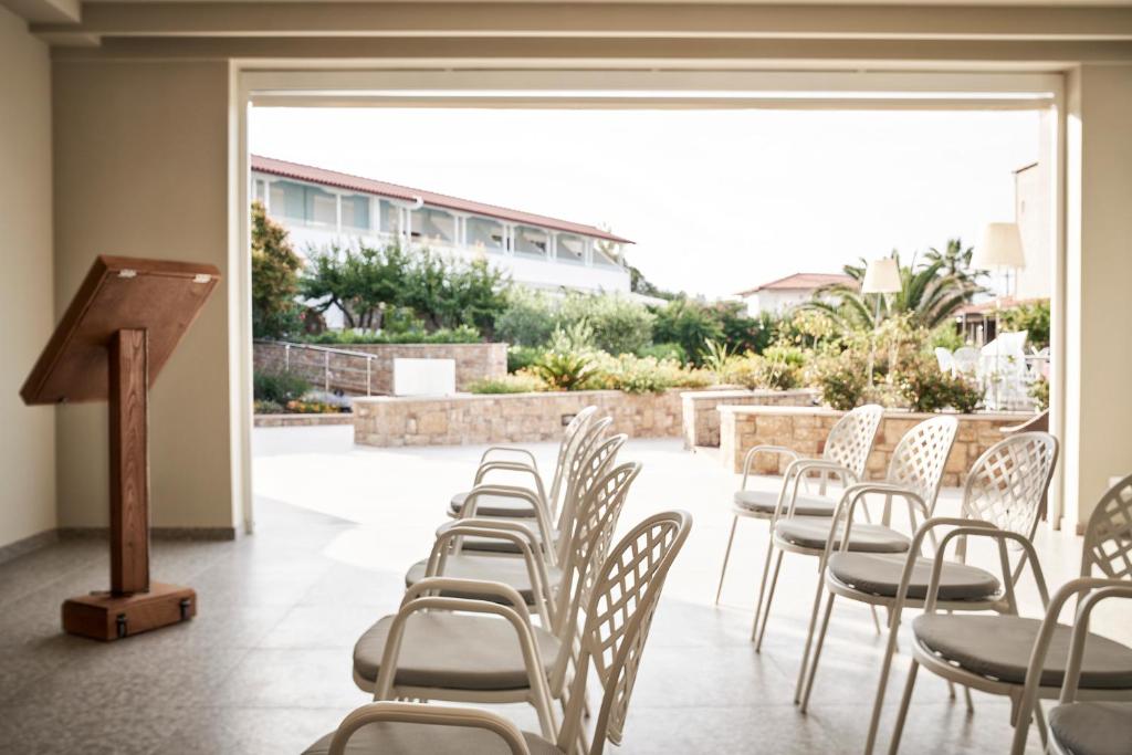 a row of chairs and a podium in a room at Antigoni Seaside Resort in Ormos Panagias