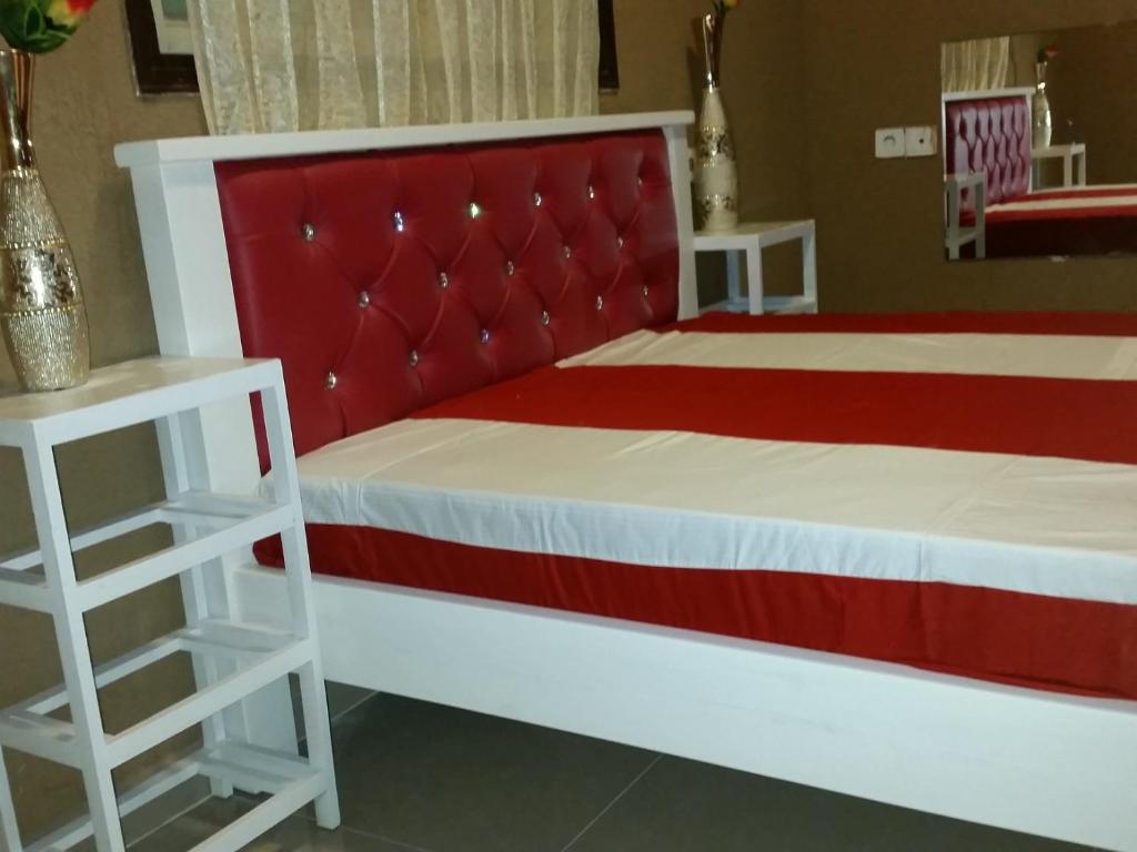 1 Schlafzimmer mit einem roten und weißen Bett und 2 Tischen in der Unterkunft vacation house יחידת אירוח פרטית רחובות in Rechovot