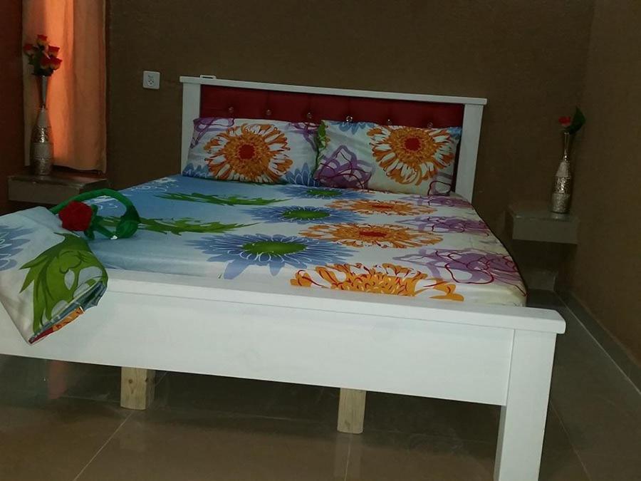 ein weißes Bett mit bunter Bettwäsche und Kissen darauf in der Unterkunft vacation house יחידת אירוח פרטית רחובות in Rechovot