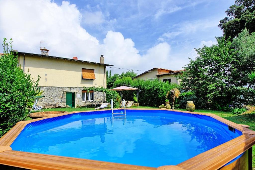 a large blue swimming pool in a yard at Casa al Bosco by PosarelliVillas in Ameglia