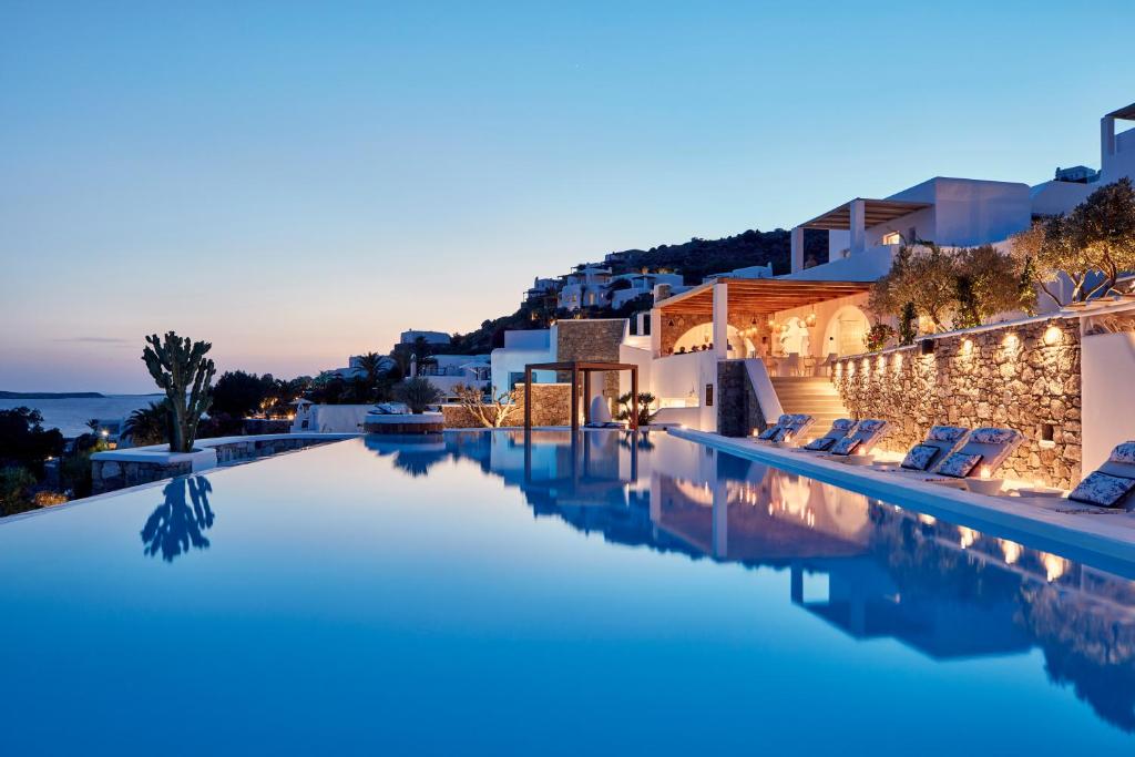 uma vista para a piscina de beiral infinito de um hotel à noite em Katikies Mykonos - The Leading Hotels of the World em Agios Ioannis Mykonos