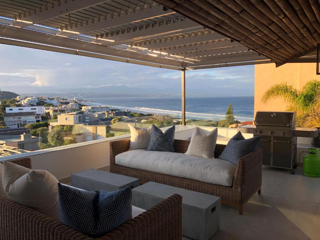 uma sala de estar com um sofá e vista para o oceano em The Sanctuary Penthouse em Plettenberg Bay