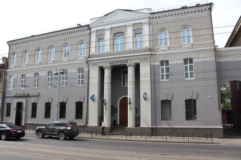 um grande edifício branco no lado de uma rua em Hotel Amurskiy em Irkutsk