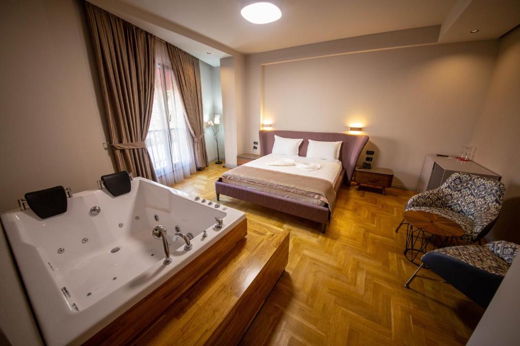 a hotel room with a tub and a bed at City Center Hotel in Tirana