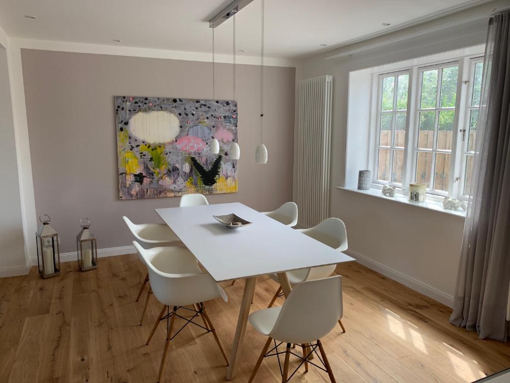 a white dining room with a white table and chairs at Hûs lepen Wil in Hörnum