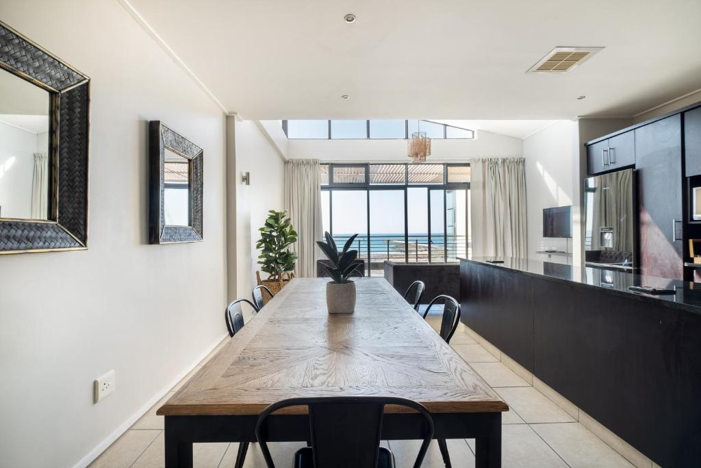 uma sala de jantar com uma mesa de madeira e cadeiras em Point Waterfront Apartments em Durban