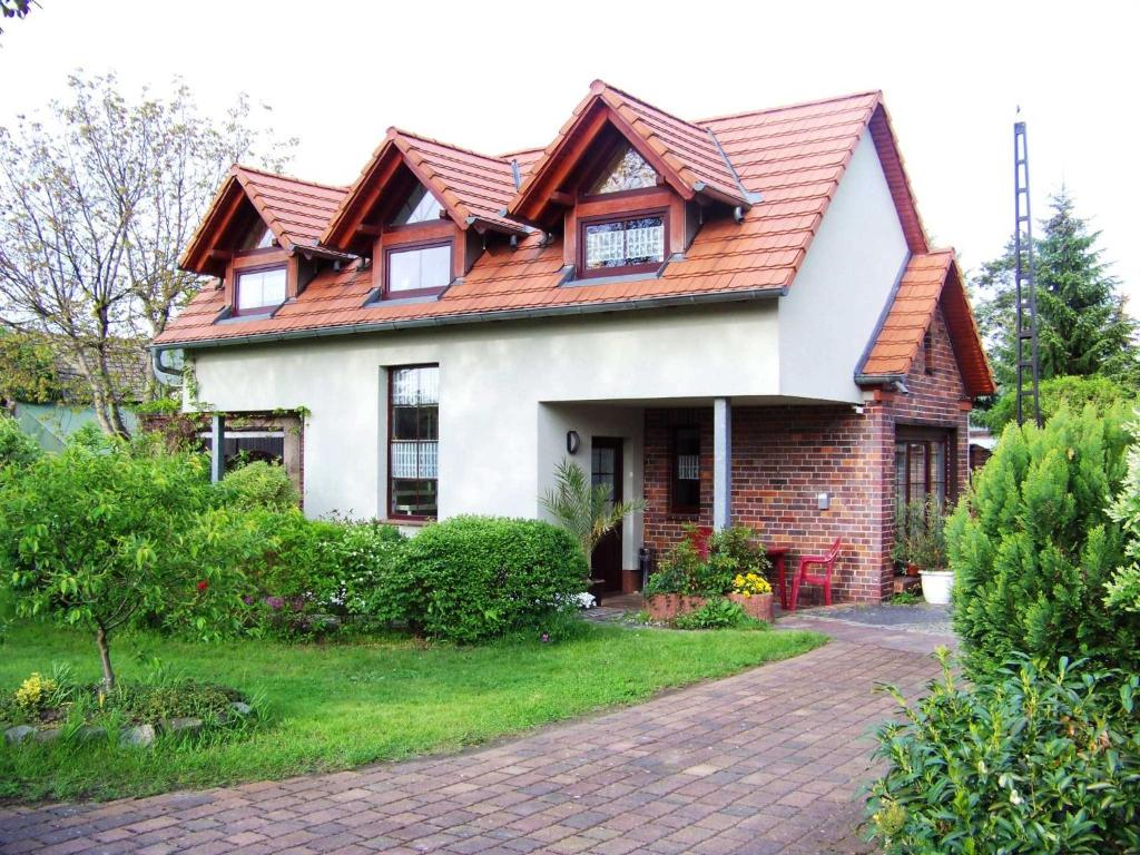 ein Haus mit rotem Dach und einer Ziegelsteinfahrt in der Unterkunft Ferienhaus Annemarie in Senftenberg
