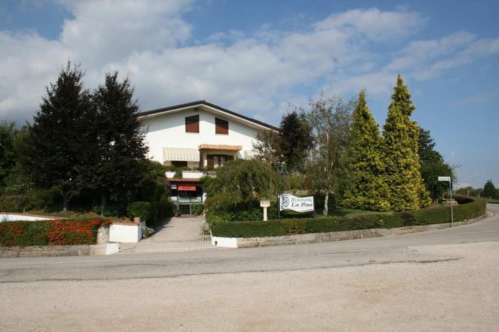 a white house with a sign on the side of a road at Hotel La Rua in Carre