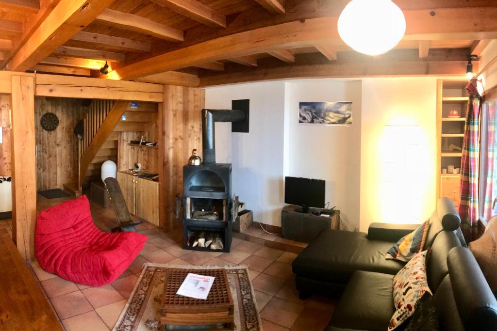 sala de estar con sofá y estufa de leña en Boréales - spacious duplex - in La Grave-La Meije heart en La Grave