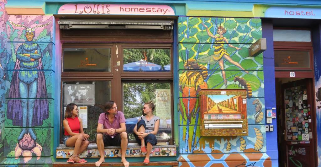 three people sitting in a store with stained glass windows at Hostel Lollis Homestay Dresden in Dresden