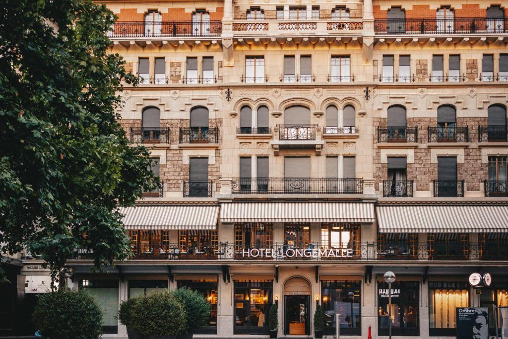 un gran edificio con un cartel en la parte delantera en Hôtel Longemalle, en Ginebra