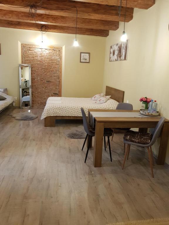 Cette chambre comprend un lit, une table et des chaises. dans l'établissement Weiss House, à Braşov