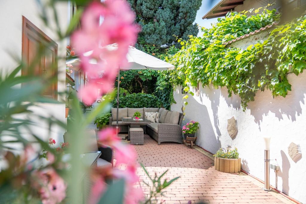 a patio with a couch and an umbrella at Laubgassl in Mörbisch am See