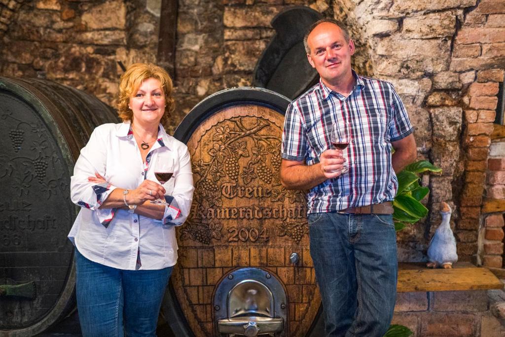 a man and a woman standing in front of a barrel at Laubgassl in Mörbisch am See