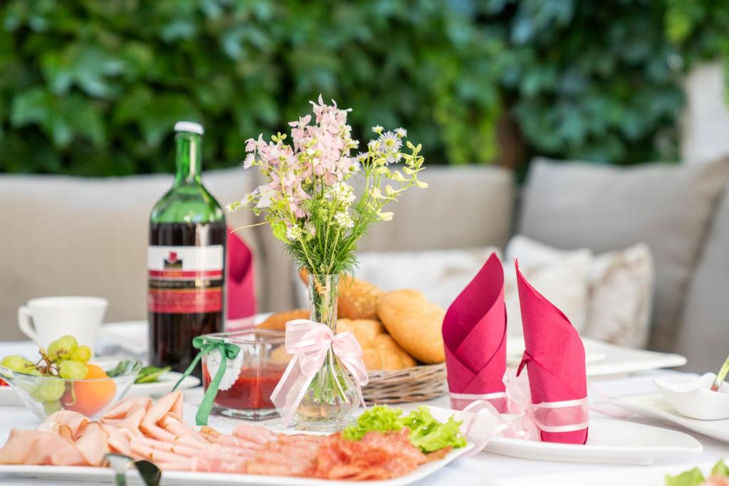 a table with a plate of food and a bottle of wine at Laubgassl in Mörbisch am See
