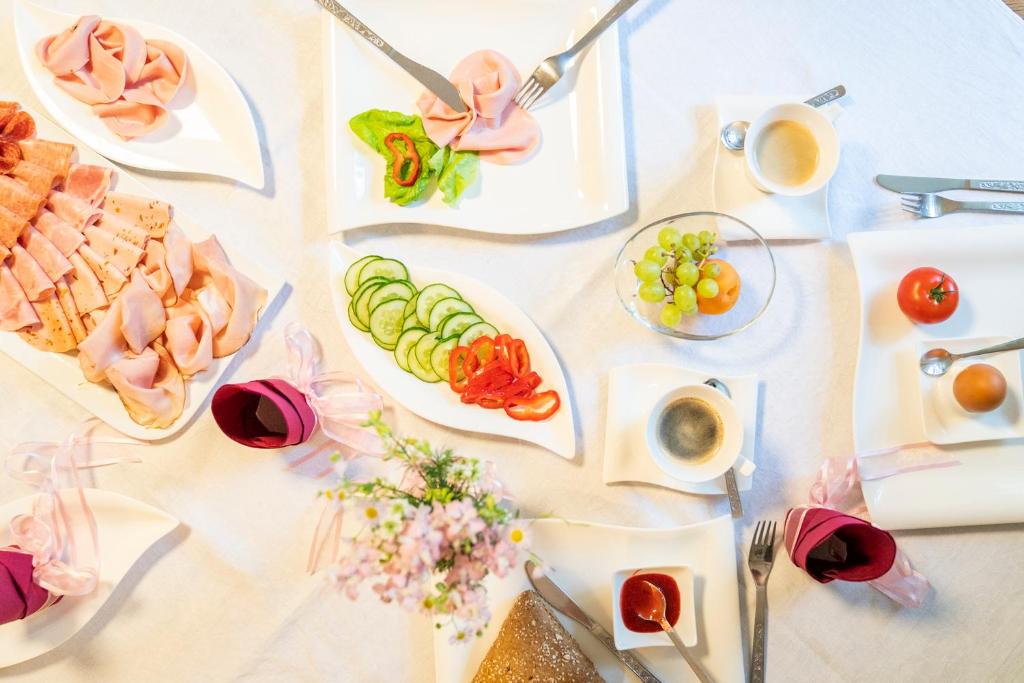 a white table with plates of food on it at Laubgassl in Mörbisch am See
