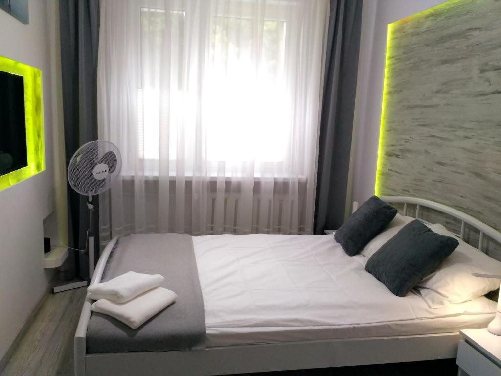a bedroom with a white bed with a window at Apartament UnoPuro w centrum Giżycka in Giżycko