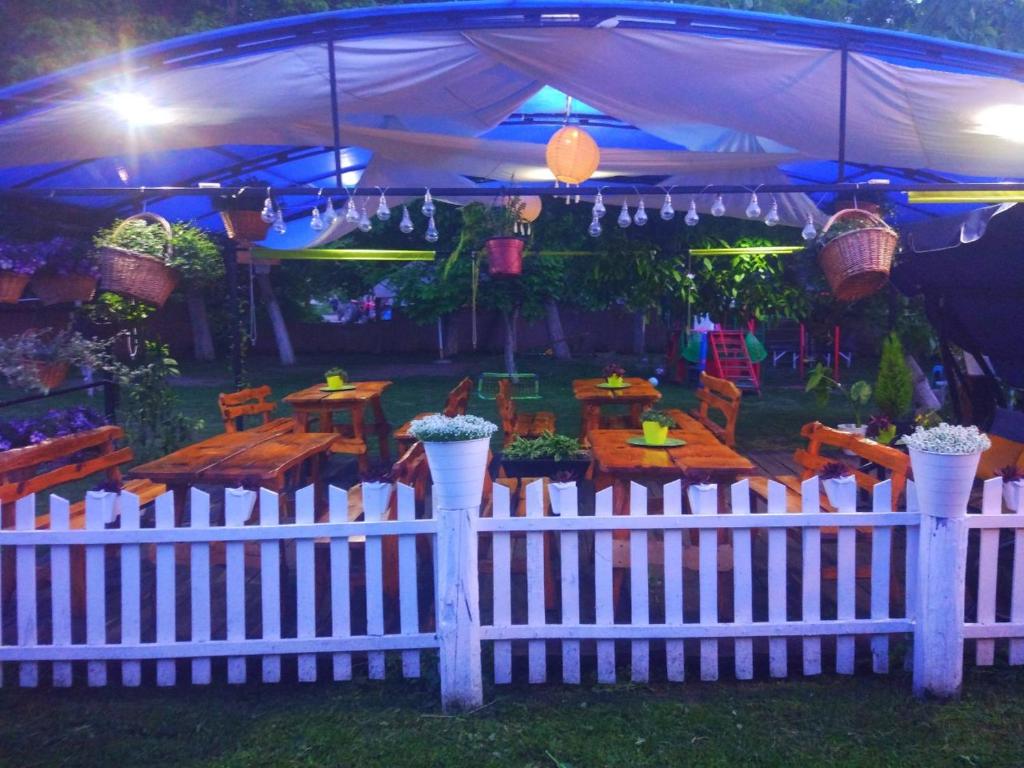 a white fence with a table and chairs under a tent at Etno selo naša avlija in Blace