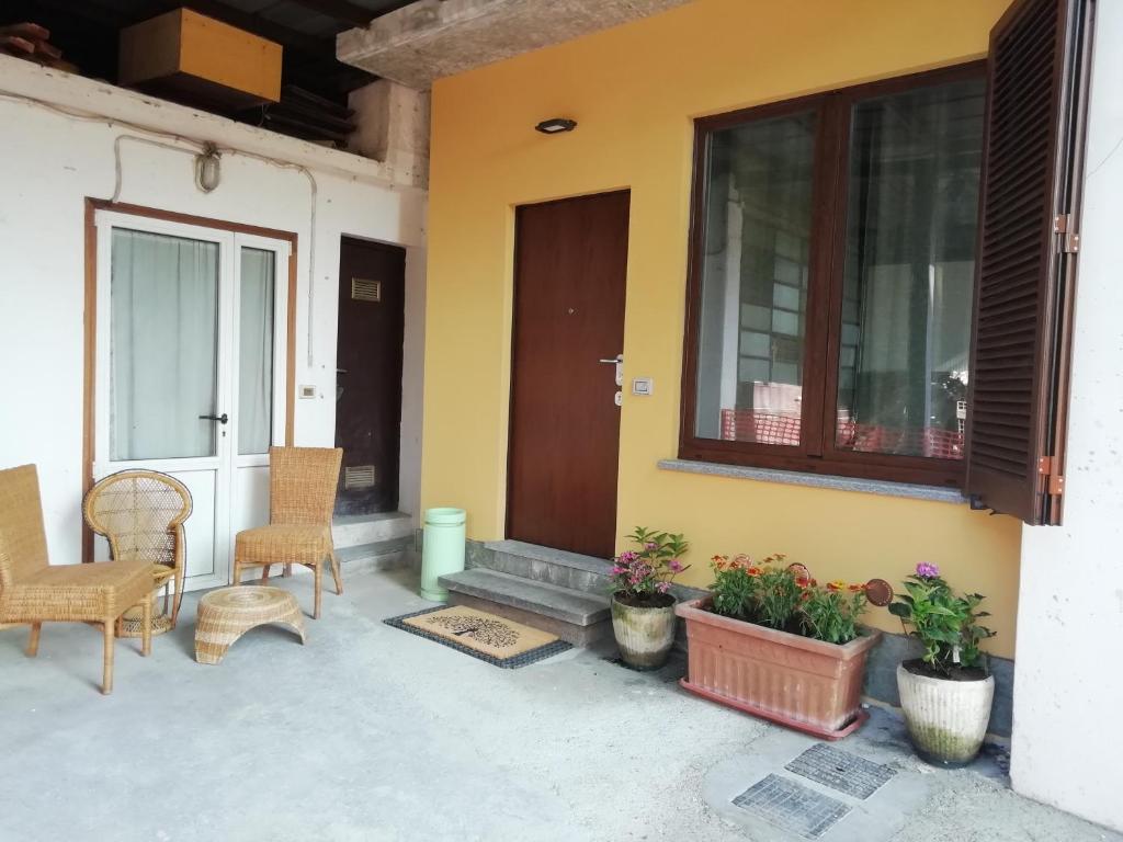 een veranda van een huis met stoelen en een deur bij La casa di Angio c cir D1135 in Lanzo dʼIntelvi