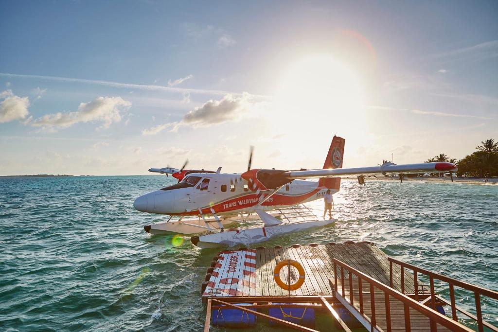 a small plane on the water next to a boat at LUX* South Ari Atoll Resort & Villas in Maamigili