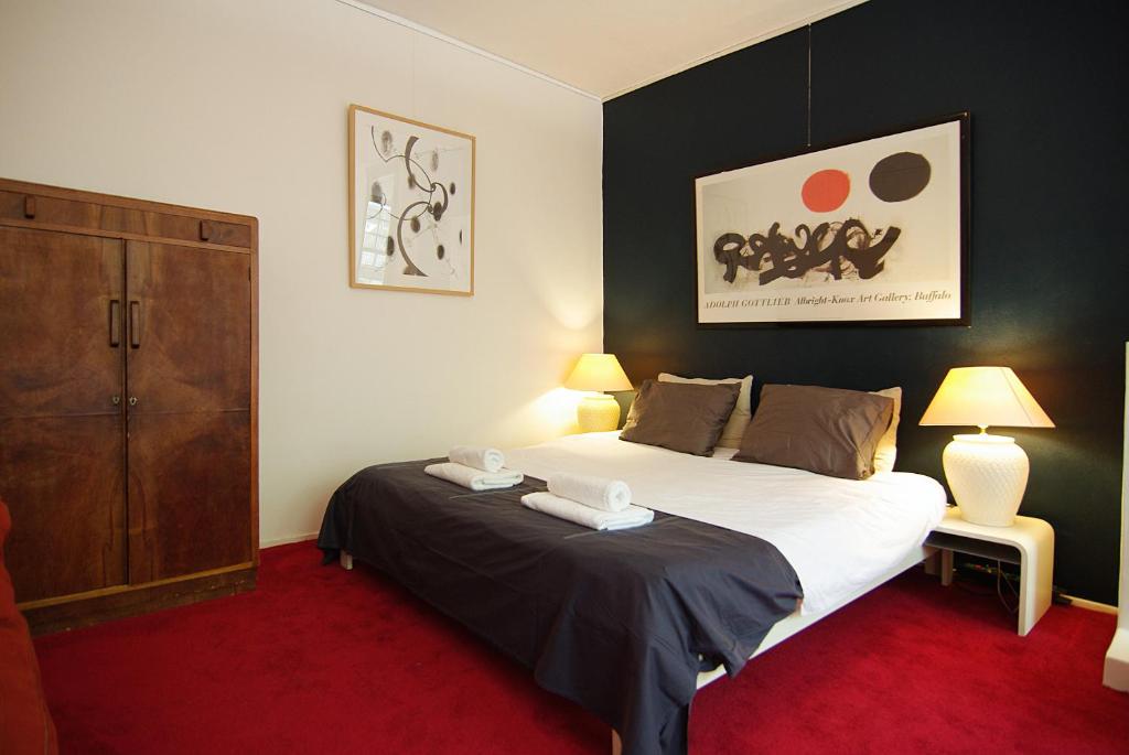 Wooden Mill B&B في أمستردام: غرفة نوم مع سرير كبير وخزانة