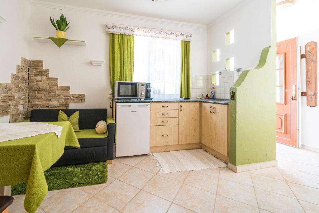 a kitchen and living room with a couch and a microwave at Laubgassl in Mörbisch am See