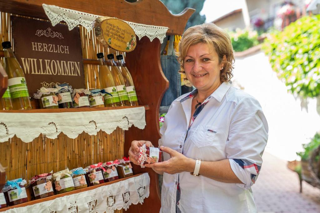 a woman standing in front of a display of wine bottles at Laubgassl in Mörbisch am See