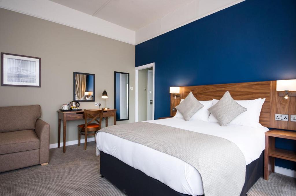 a hotel room with a large bed and a desk at The Beverley by Innkeeper's Collection in Cardiff