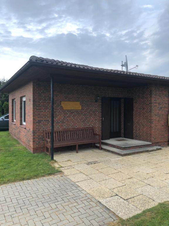 un bâtiment en briques avec un banc devant lui dans l'établissement Haus Horst, à Schillig