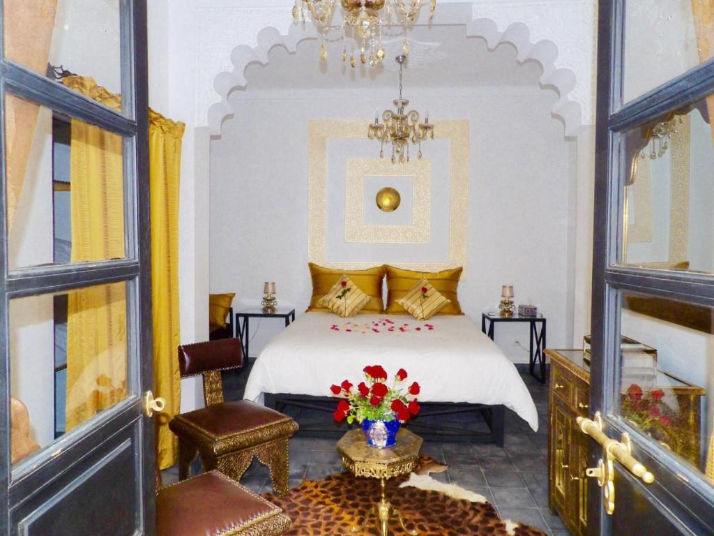 Schlafzimmer mit einem Bett und einem Kronleuchter in der Unterkunft La Voûte Étoilée in Marrakesch