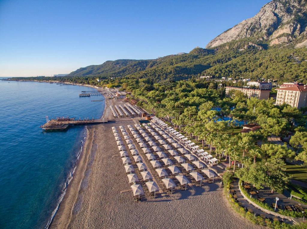 eine Luftansicht auf einen Strand mit Sonnenschirmen und Wasser in der Unterkunft Akka Antedon Hotel - Premium Ultra All Inclusive in Beldibi