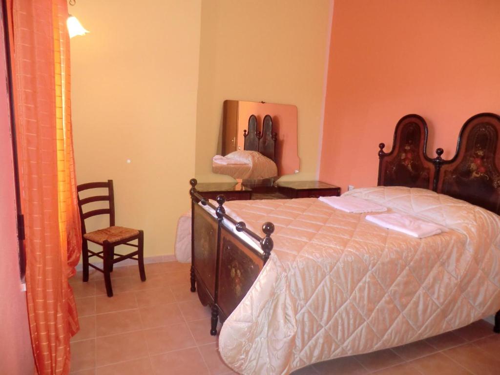 a bedroom with a large bed and a chair at Agriturismo Lerno in Pattada