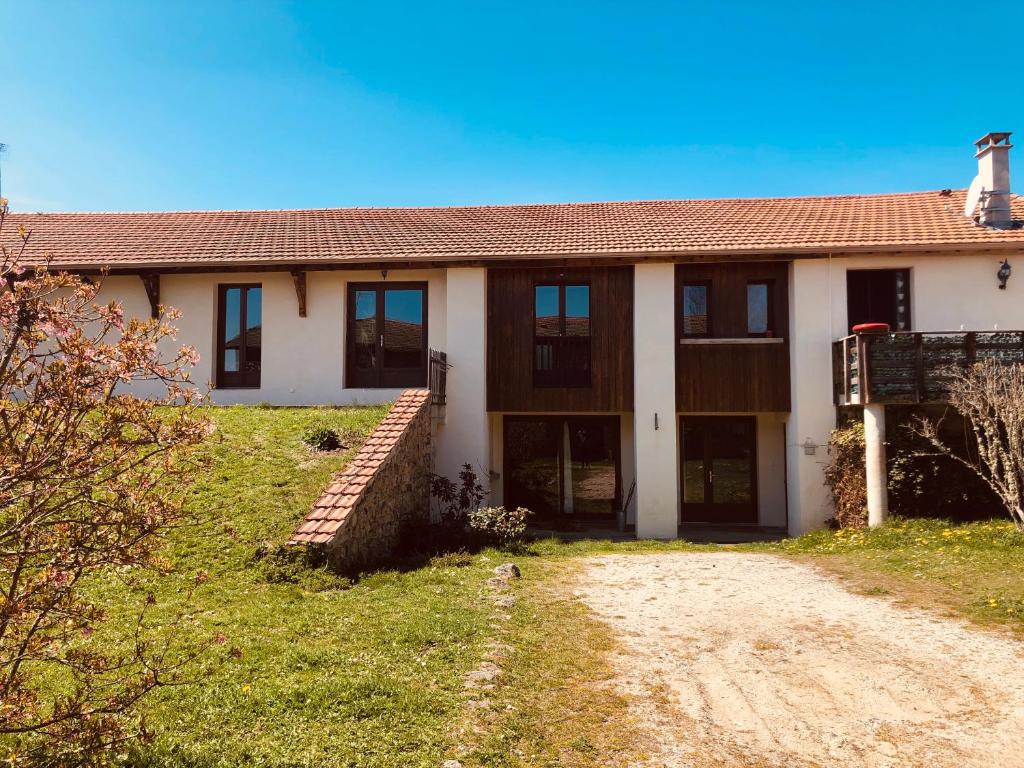 une maison avec un chemin de terre devant elle dans l'établissement Le Champ, à La Chaise-Dieu