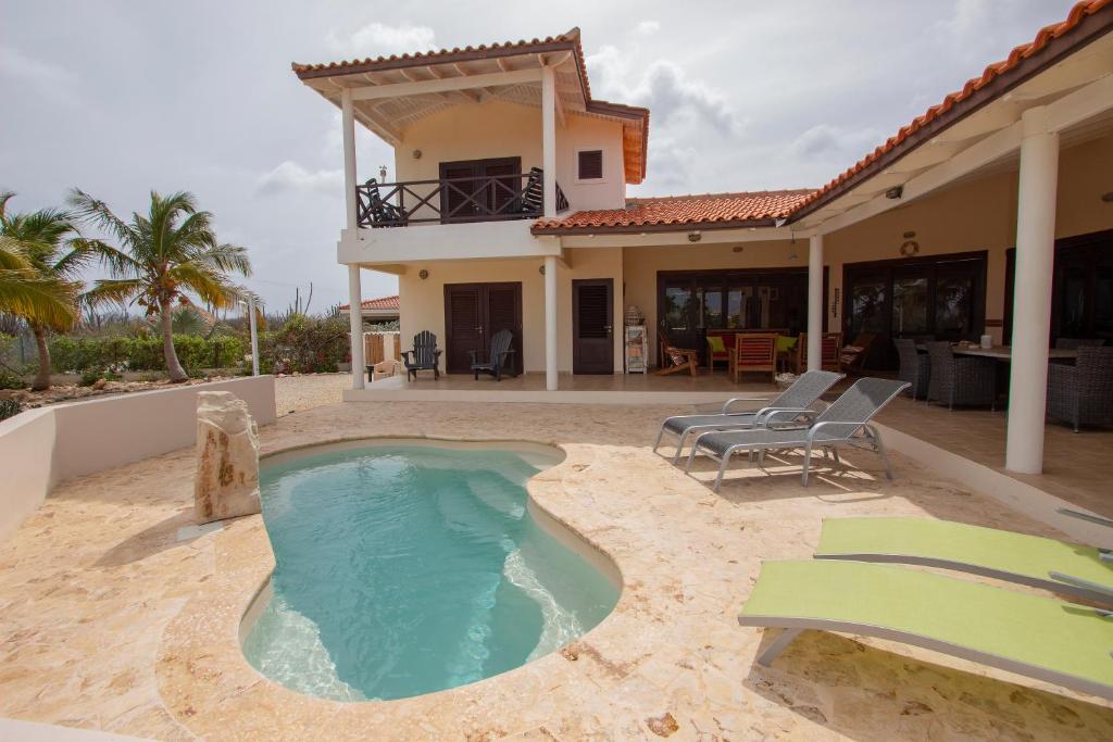 a swimming pool in the backyard of a house at Casa Coco Bonaire at Sabalpalm Villas in Kralendijk