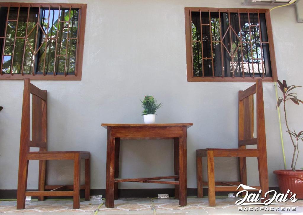 una mesa y dos sillas sentadas junto a una pared en JaiJai's Backpackers en Corón
