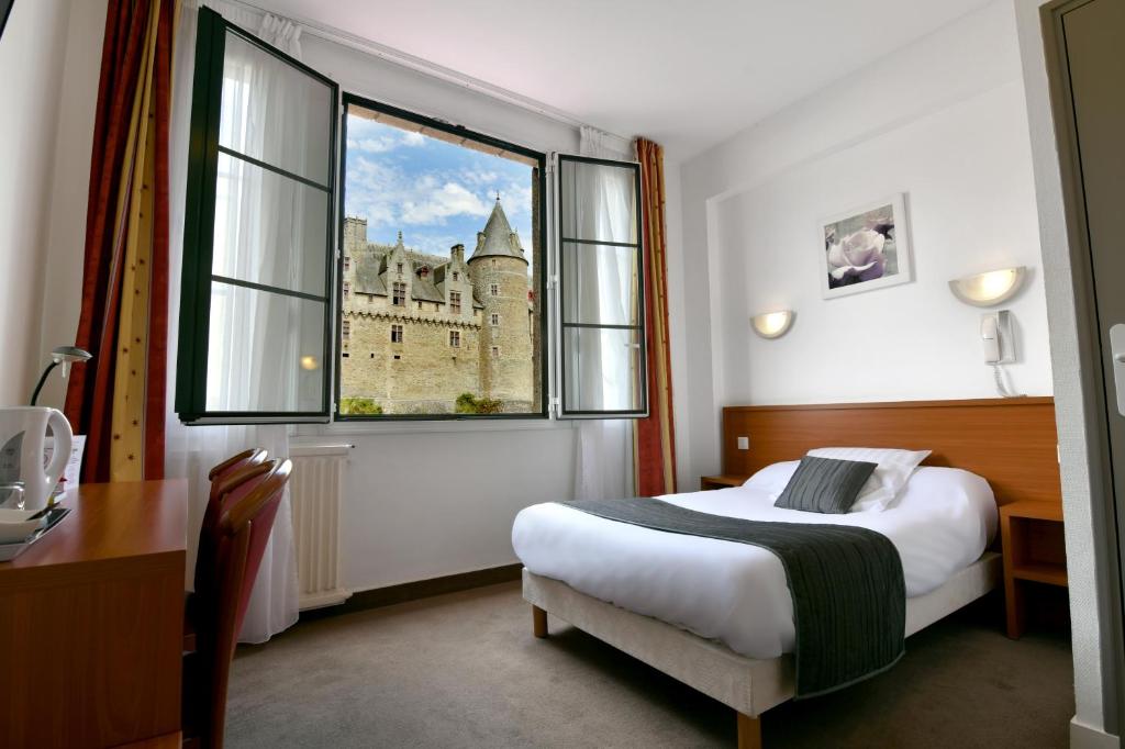 a hotel room with a bed and a large window at Hôtel Restaurant Du Château in Josselin