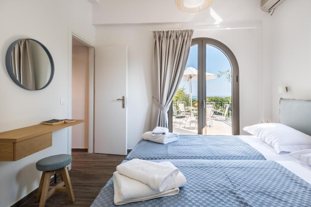 a bedroom with a bed and a mirror and a window at Ktima Fabiatos in Skala Kefalonias