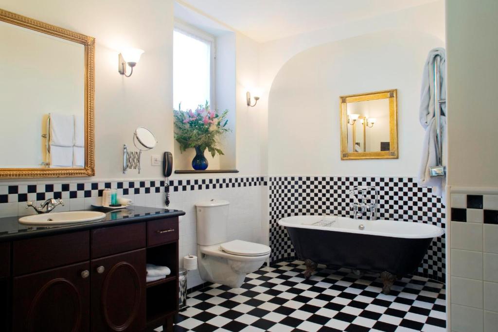 a bathroom with a tub and a toilet and a sink at The American Colony Hotel - Small Luxury Hotels of the World in Jerusalem