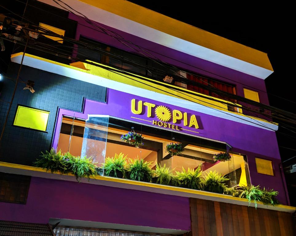 a building with a sign that reads utpta hotels at Utopia Hostel in Aparecida