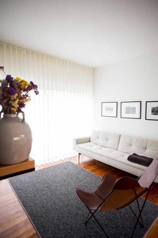 a living room with a white couch and a vase at Furnas Lake Forest Living in Furnas