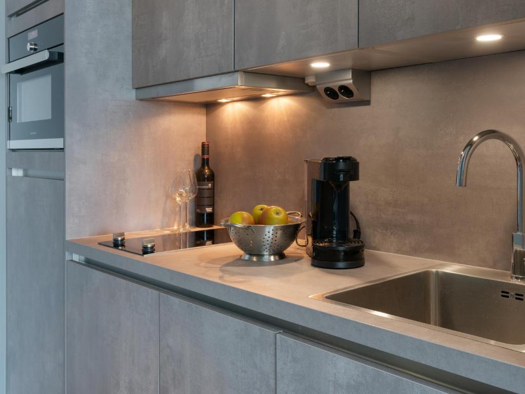 eine Küche mit einem Waschbecken und einer Schale Obst in der Unterkunft Appartement FördeHimmel in Glücksburg