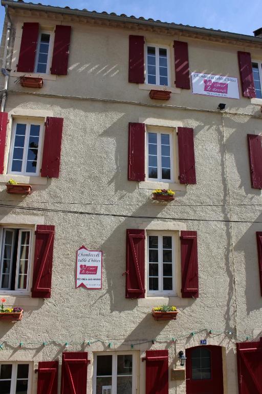 a building with red shutters and a sign on it at Au Coeur de Rennes Chambres d'hôtes in Rennes-les-Bains
