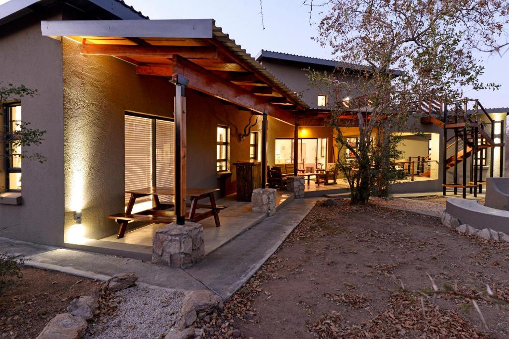 Sweni Lodge 91 Mjejane Kruger Park في هكتورسبروت: منزل مع شرفة مع سقف خشبي