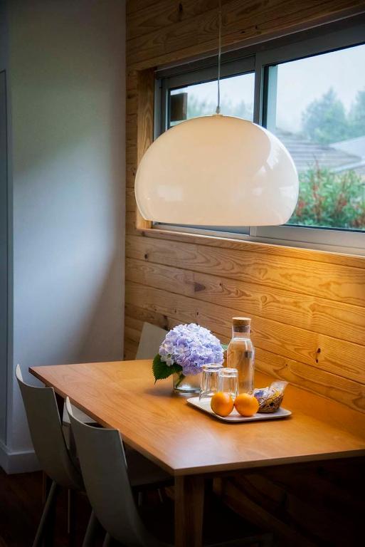 a wooden table with a plate of fruit and a lamp at Furnas Lake Forest Living in Furnas