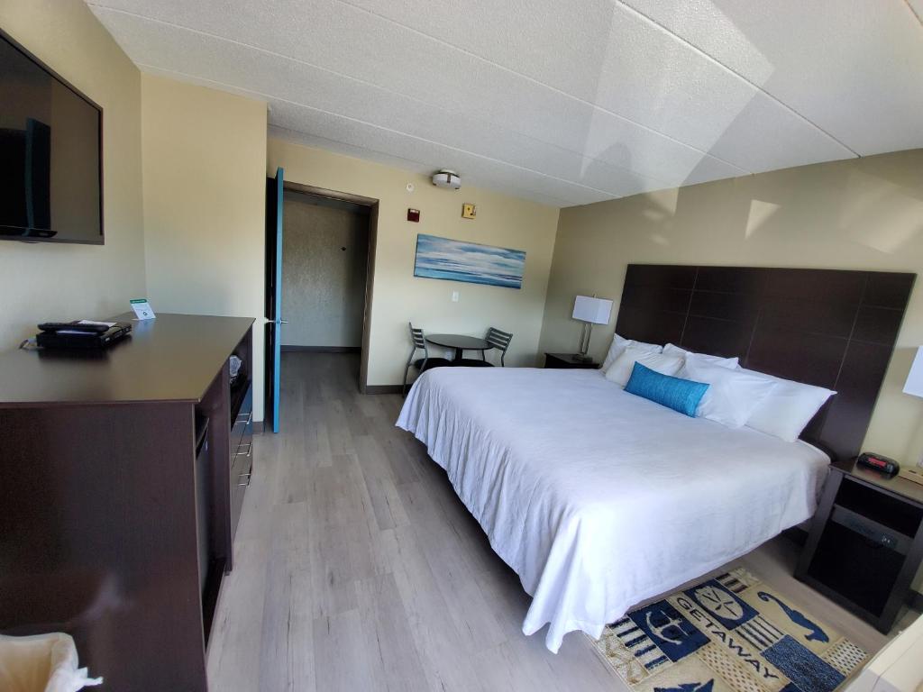 Habitación de hotel con cama grande y escritorio. en The Dunes Rehoboth Beach, en Dewey Beach