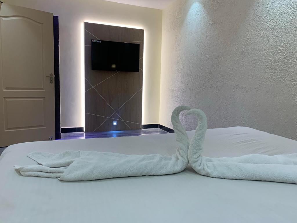 a bed with two towels on it with a mirror at Hotel Temple City in Madurai
